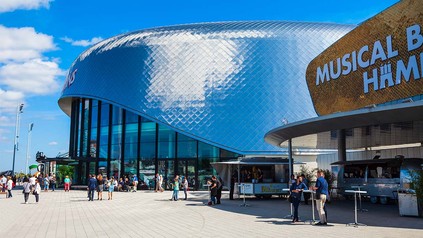 Außenansicht auf das Musical-Gebäude in Hamburg, mit Food-Trucks und gutem Wetter.