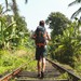 Junger Mann mit Rucksack unterwegs in den Tropen. (Foto: © NDStock/GettyImages)