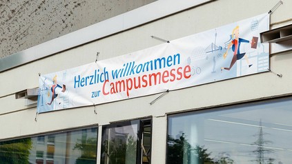 Ein Banner mit der Werbung für die Campusmesse in Düsseldorf vor grauem Hintergrund. (Foto: © HHU / Christoph Kawan)