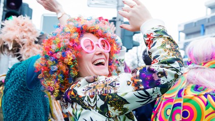 Junge Frau mit bunter Perücke beim Fasching