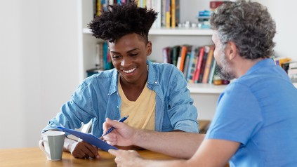 Lachender afrikanischer Student beim Beratungsgespräch