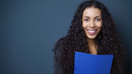 Lächelnde Frau mit Bewerbungsmappe in der Hand.